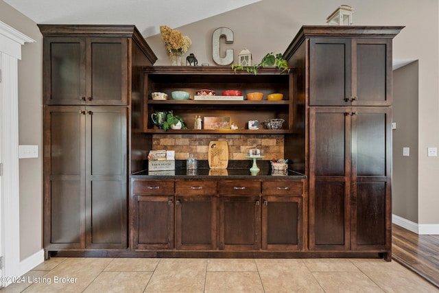 bar featuring light tile patterned floors and baseboards