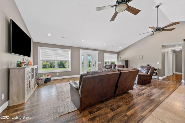 living area with plenty of natural light, visible vents, vaulted ceiling, and wood finished floors