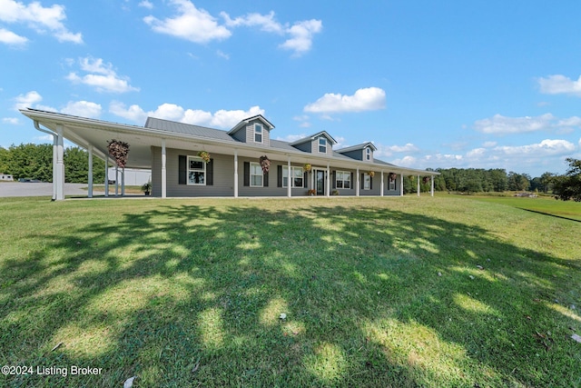 view of front of property with an attached carport, covered porch, metal roof, and a front lawn