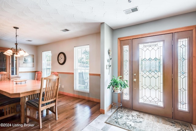 foyer featuring hardwood / wood-style flooring and a notable chandelier