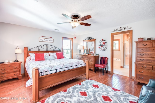 bedroom featuring a textured ceiling, connected bathroom, hardwood / wood-style floors, and ceiling fan