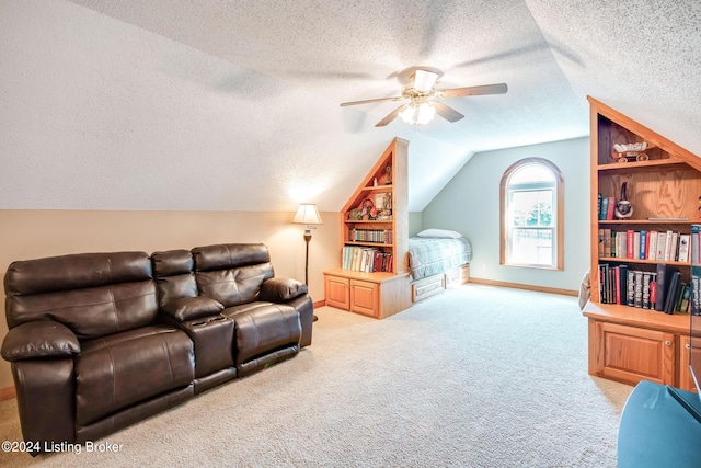 carpeted living room with vaulted ceiling, a textured ceiling, and ceiling fan