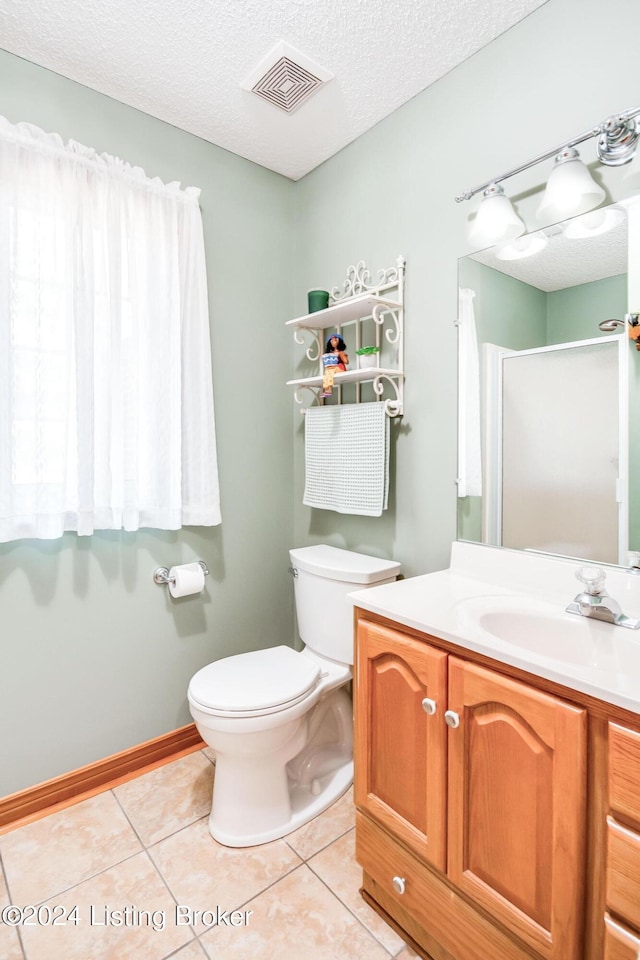 bathroom featuring vanity, toilet, a textured ceiling, and tile patterned flooring