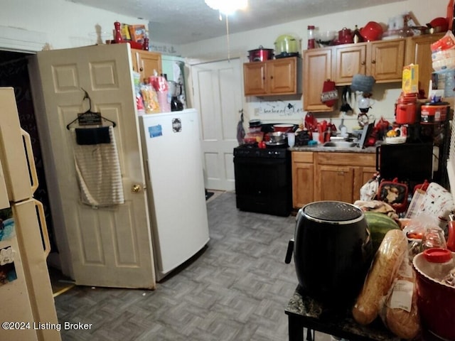 kitchen featuring black electric range oven and white fridge