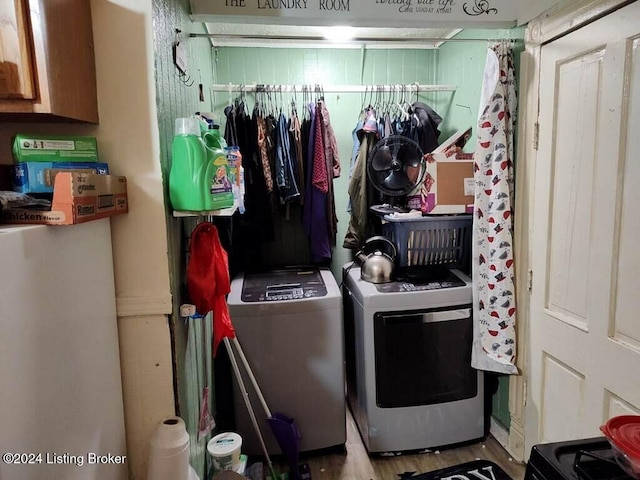 laundry room with washer and clothes dryer and light hardwood / wood-style flooring