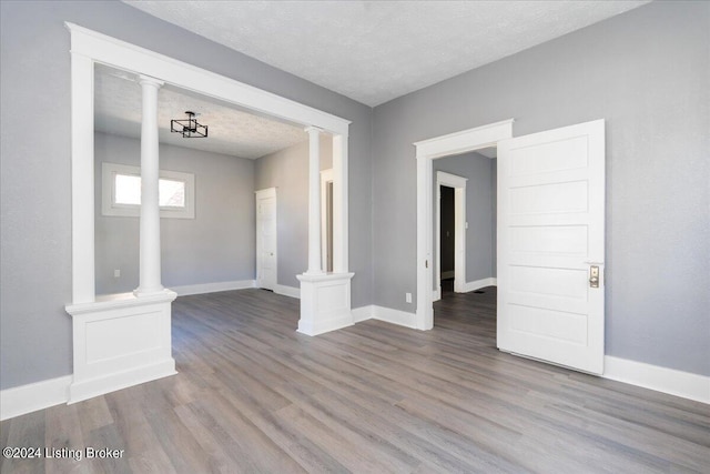 spare room with a textured ceiling and hardwood / wood-style floors