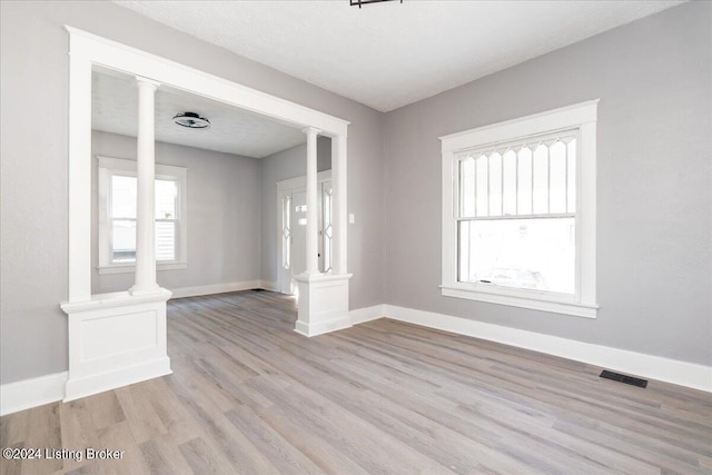 unfurnished room featuring light hardwood / wood-style flooring and a textured ceiling