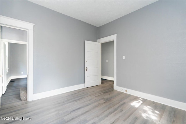 spare room featuring a textured ceiling and light wood-type flooring