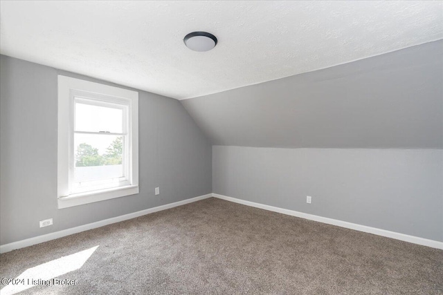 bonus room featuring lofted ceiling, carpet, and a textured ceiling