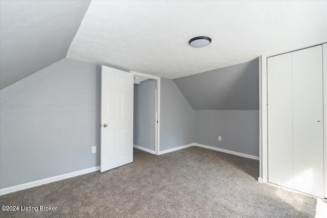 bonus room with lofted ceiling, a textured ceiling, and carpet flooring