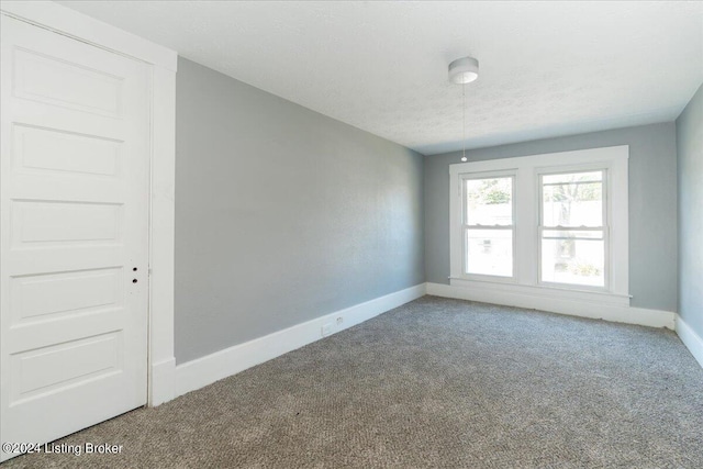 carpeted empty room featuring a textured ceiling