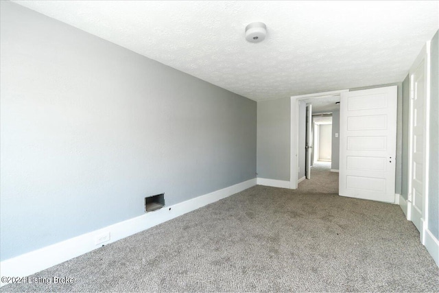 carpeted spare room featuring a textured ceiling