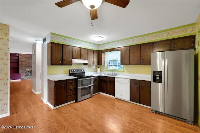 kitchen featuring dark brown cabinets, appliances with stainless steel finishes, sink, ceiling fan, and light wood-type flooring