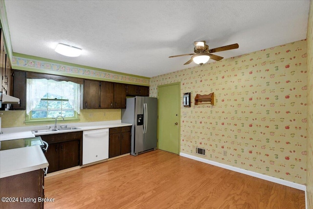 kitchen featuring stainless steel fridge, light hardwood / wood-style flooring, white dishwasher, sink, and dark brown cabinetry