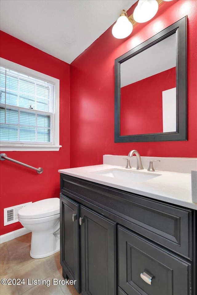 bathroom with tile patterned flooring, vanity, and toilet