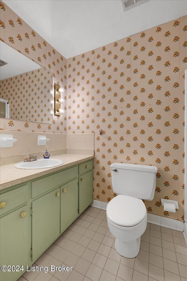 bathroom featuring vanity, tasteful backsplash, toilet, and tile patterned flooring