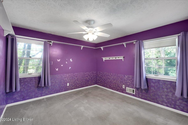 empty room with a textured ceiling, ceiling fan, and carpet floors