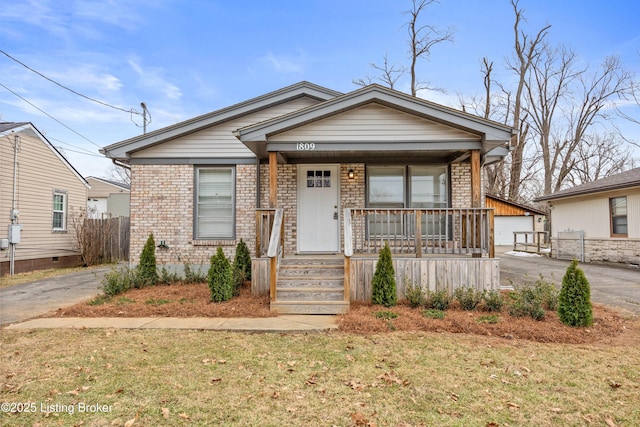 view of front of property with a garage, an outbuilding, a front yard, and covered porch