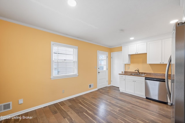 kitchen featuring appliances with stainless steel finishes, dark hardwood / wood-style floors, sink, white cabinets, and crown molding