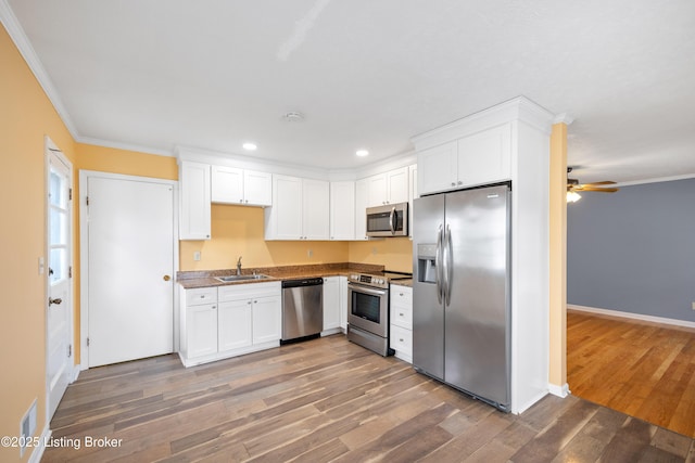 kitchen with white cabinetry, appliances with stainless steel finishes, sink, and dark wood-type flooring