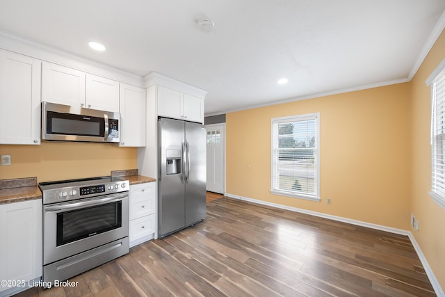 kitchen featuring ornamental molding, appliances with stainless steel finishes, dark hardwood / wood-style floors, and white cabinets