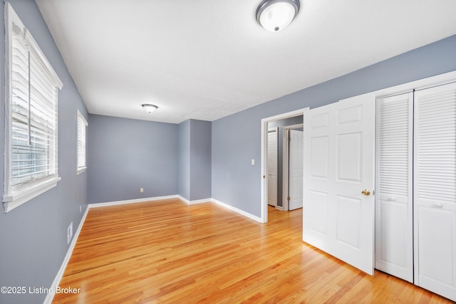 unfurnished bedroom with light hardwood / wood-style floors and a closet