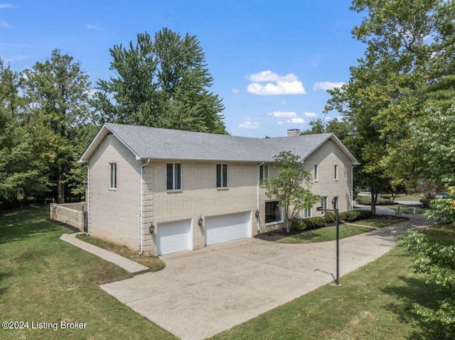 view of front of home featuring brick siding, a chimney, a front yard, a garage, and driveway