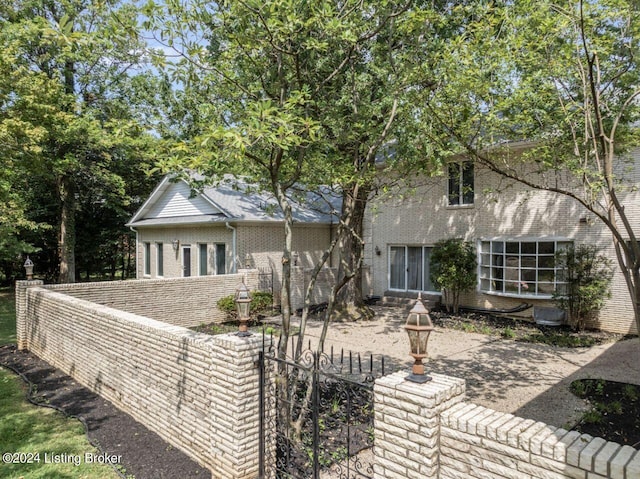 view of front facade with brick siding and fence