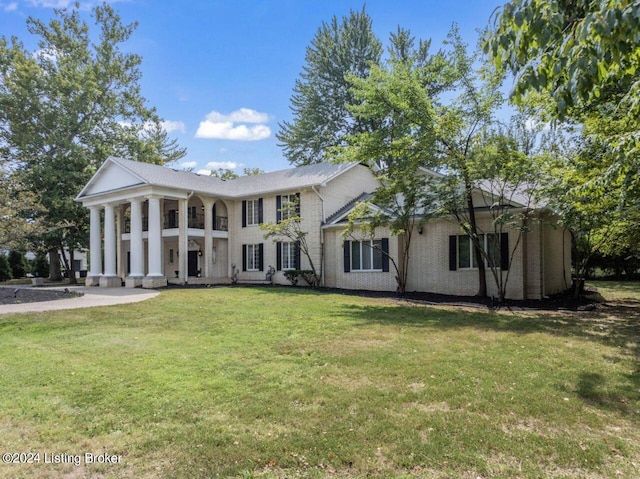 greek revival house featuring a front yard