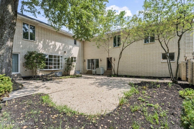 rear view of house with entry steps and brick siding