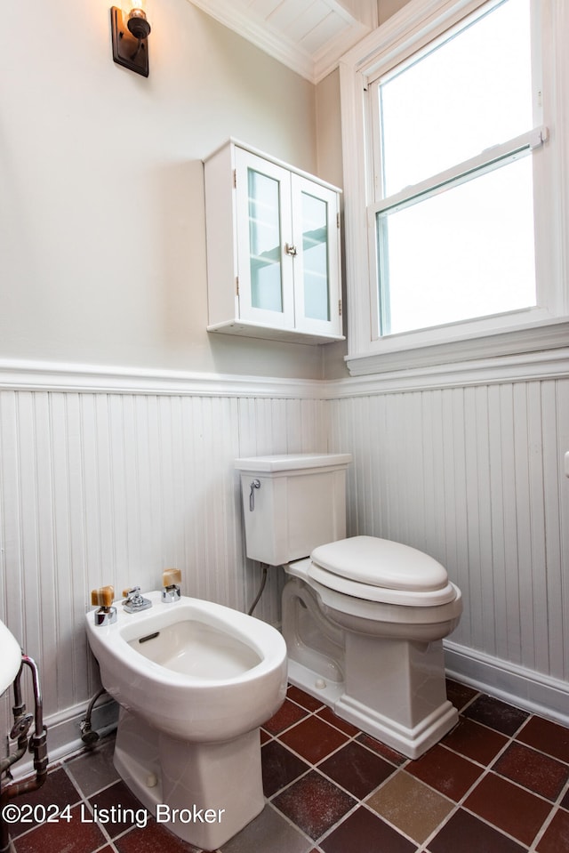 bathroom with tile patterned flooring, toilet, a bidet, and ornamental molding