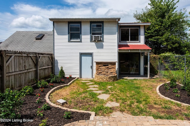 rear view of property with stone siding, a fenced backyard, and cooling unit