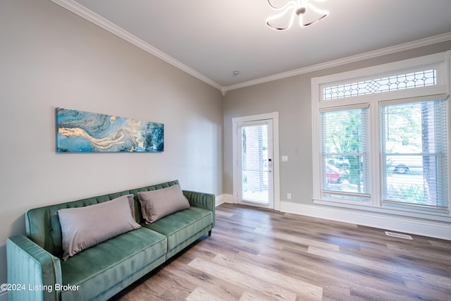 living room featuring lofted ceiling, crown molding, an inviting chandelier, and light hardwood / wood-style floors