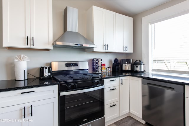 kitchen with white cabinets, appliances with stainless steel finishes, wall chimney exhaust hood, and a healthy amount of sunlight