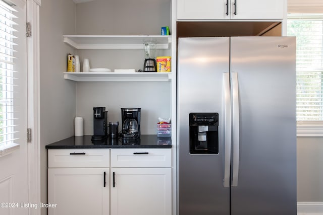 interior space featuring white cabinets, a wealth of natural light, and stainless steel fridge with ice dispenser