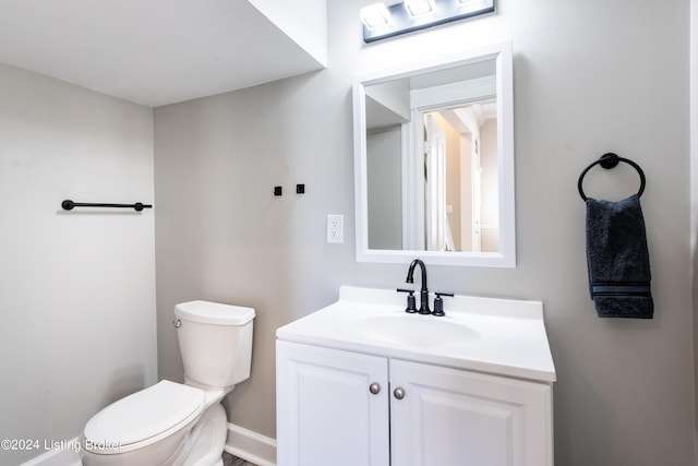 half bathroom with toilet and vanity