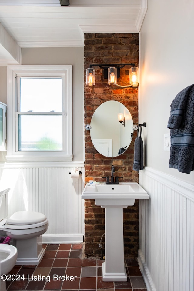 bathroom featuring a bidet, toilet, ornamental molding, and tile patterned floors