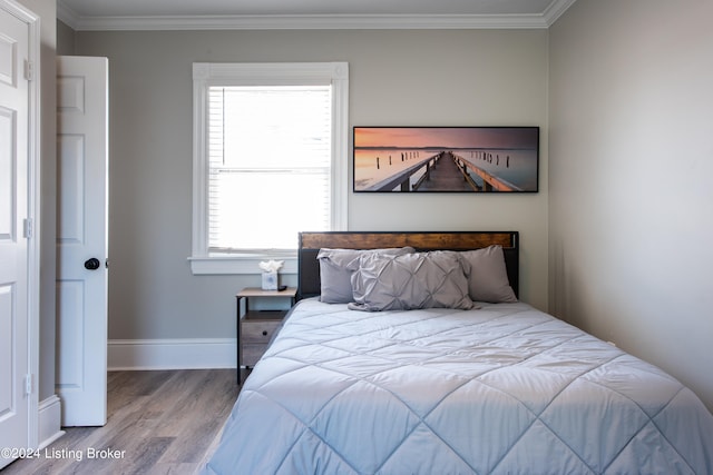 bedroom with wood-type flooring and crown molding