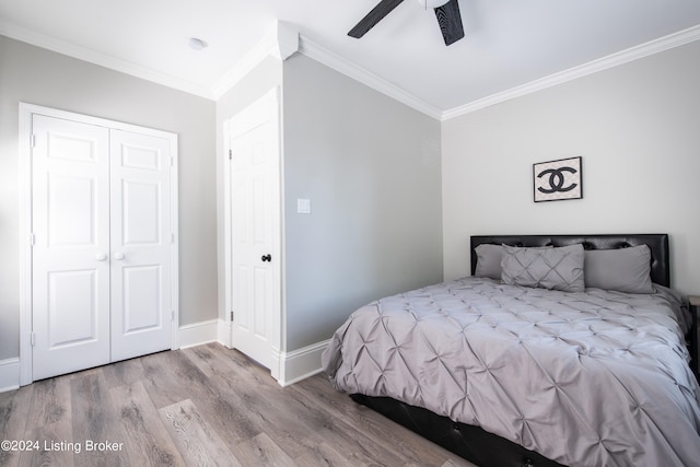 bedroom with light wood-type flooring, a closet, ceiling fan, and ornamental molding