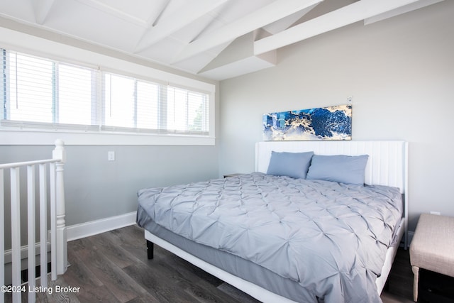 bedroom featuring lofted ceiling with beams, baseboards, and wood finished floors