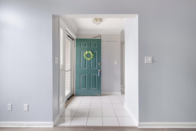 entrance foyer with crown molding and light tile patterned floors