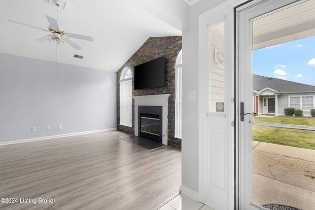 living room with lofted ceiling, light hardwood / wood-style floors, ceiling fan, and a fireplace