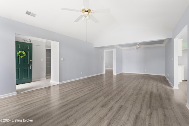 unfurnished living room featuring ornamental molding, vaulted ceiling, ceiling fan, and light hardwood / wood-style floors