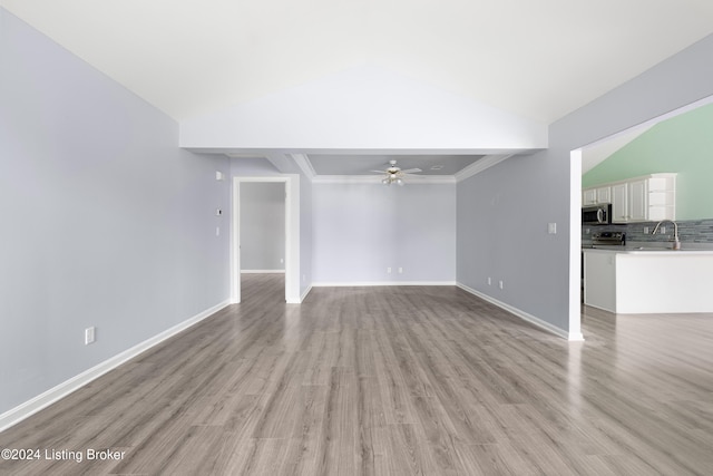 unfurnished living room featuring vaulted ceiling, light hardwood / wood-style flooring, sink, and ceiling fan