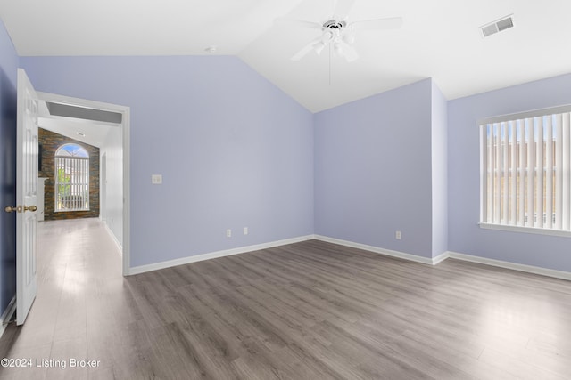 spare room featuring lofted ceiling, ceiling fan, and light wood-type flooring