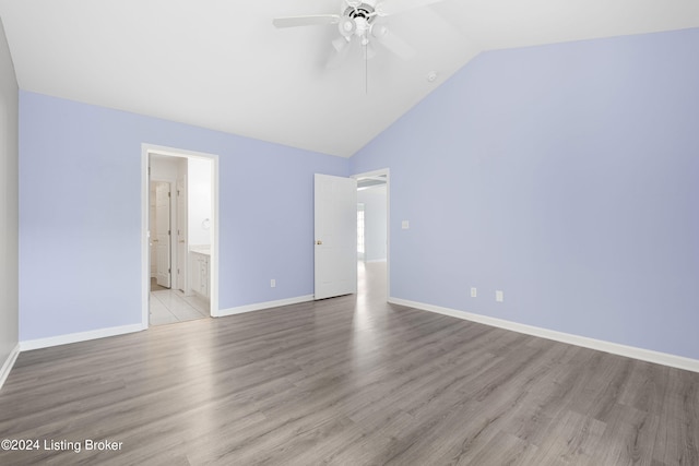 unfurnished bedroom with lofted ceiling, light hardwood / wood-style floors, connected bathroom, and ceiling fan