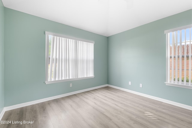 unfurnished room with light wood-type flooring and a wealth of natural light