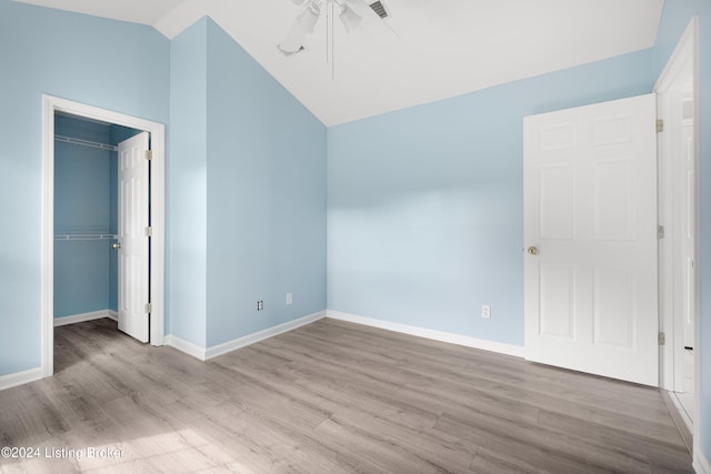 unfurnished bedroom with light wood-type flooring, a closet, ceiling fan, and lofted ceiling