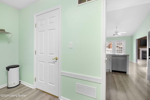 hallway with light wood-type flooring and lofted ceiling