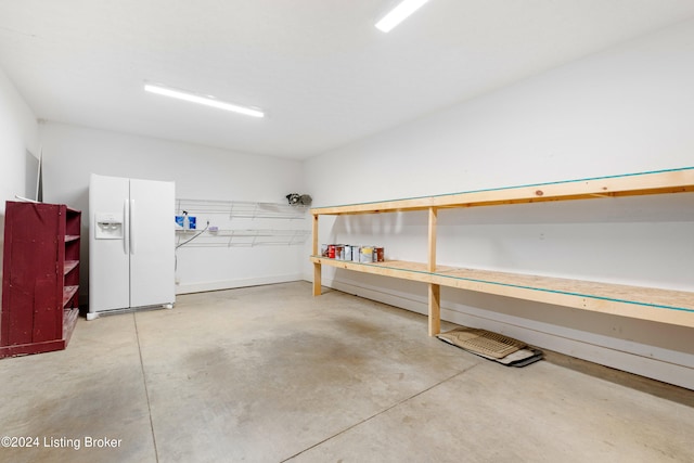 garage featuring white refrigerator with ice dispenser